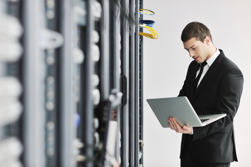 Man with laptop in server room